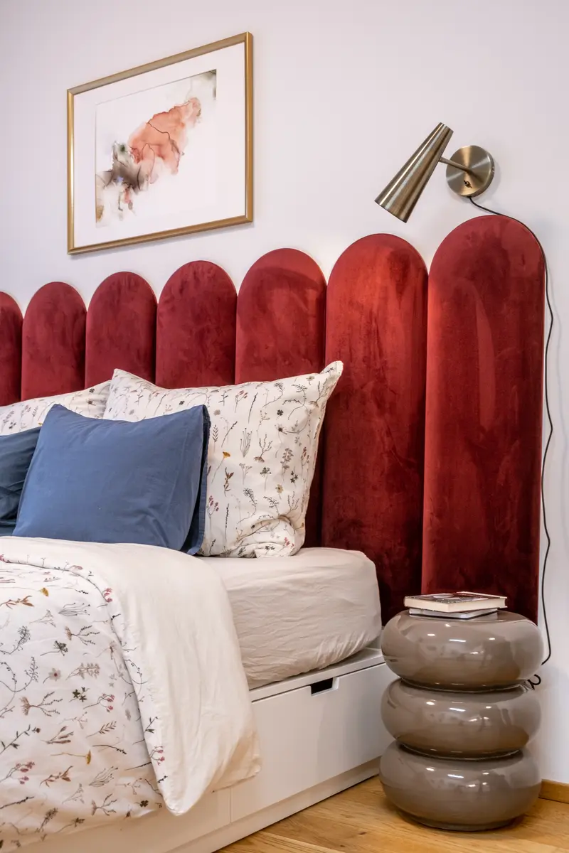 Velvet scalloped headboard close-up with designer pillows