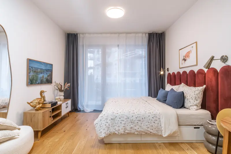 Stylish bedroom with burgundy velvet headboard and oak floors