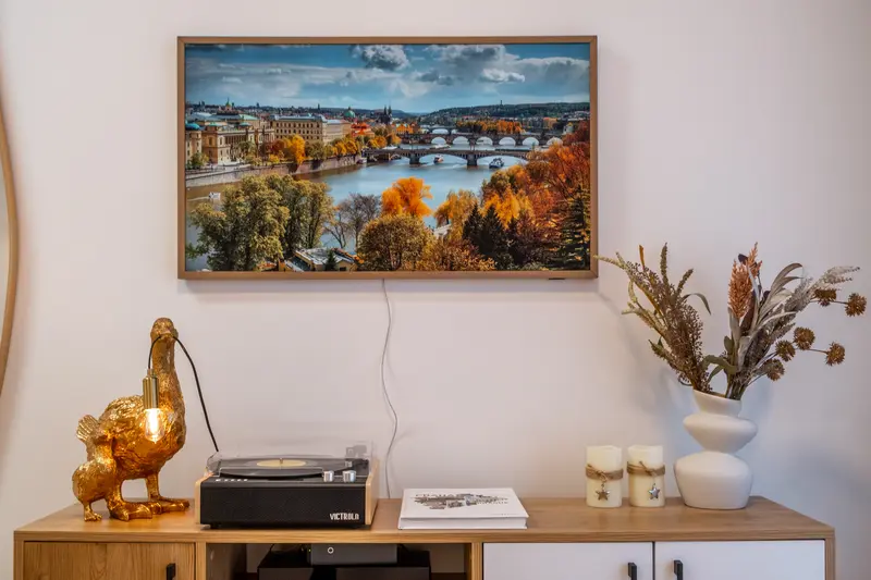 Smart TV showing Prague panorama, Victrola record player, golden duck lamp