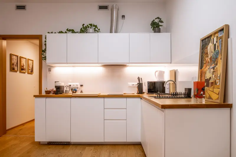 Modern L-shape kitchen with white cabinets and oak countertops